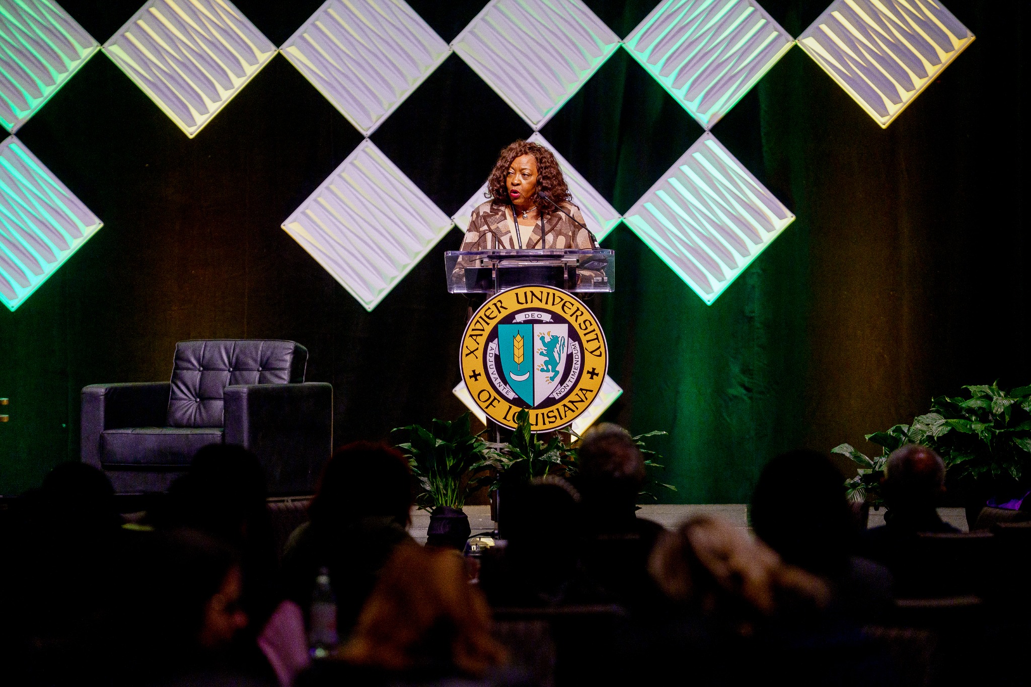 Dr. Kennedy speaking at a Xavier conference podium